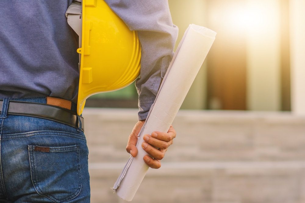Architecture,Engineer,Holding,Hard,Hat,On,Site,Building,Construction,Background